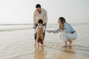 Photo de famille marchant main dans la main sur la plage de Plouharnel