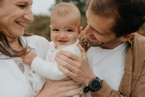 Bébé entouré de ses parents pendant une séance photo famille dans le Morbihan