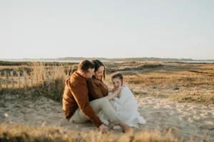 moment de rire famille pour une seance photo grossesse morbihan proche de vannes la mer en fond