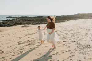 rire femme enceinte et sa fille en train de courir sur la plage à locmariaquer dans le morbihan