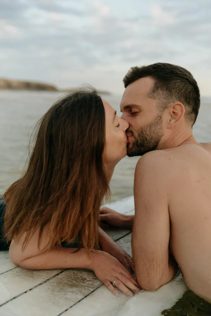 Baiser du couple dans l'eau lors de la séance photo
