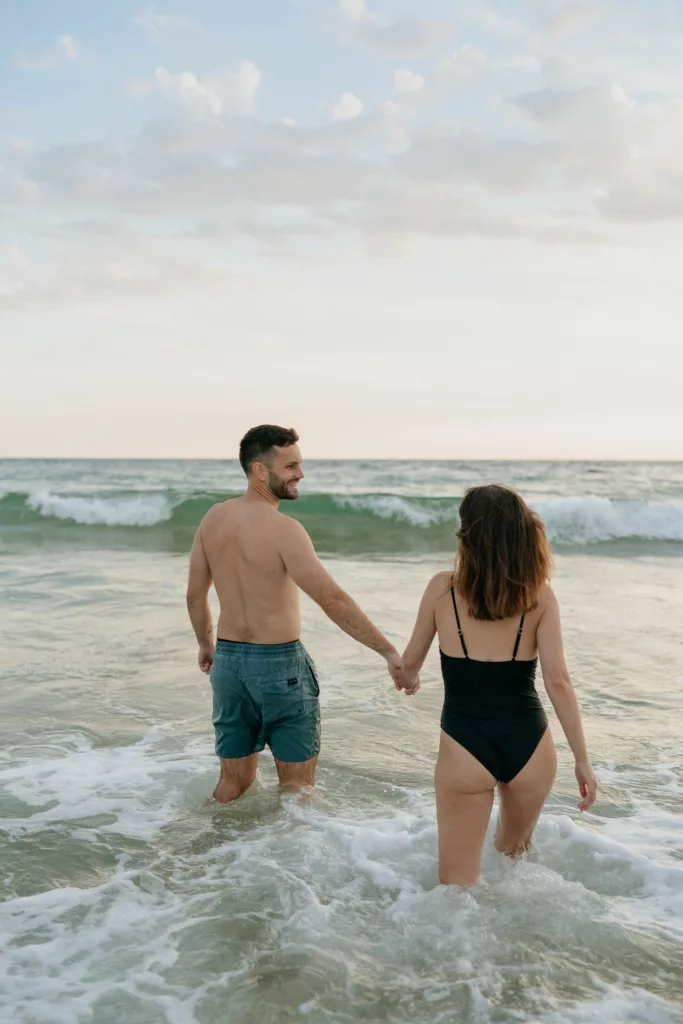 Couple debout dans l'eau jusqu'aux genoux plage bretonne