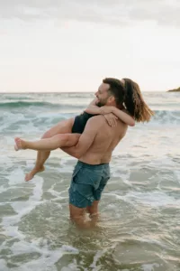 Éclat de rire du couple sous les embruns marins