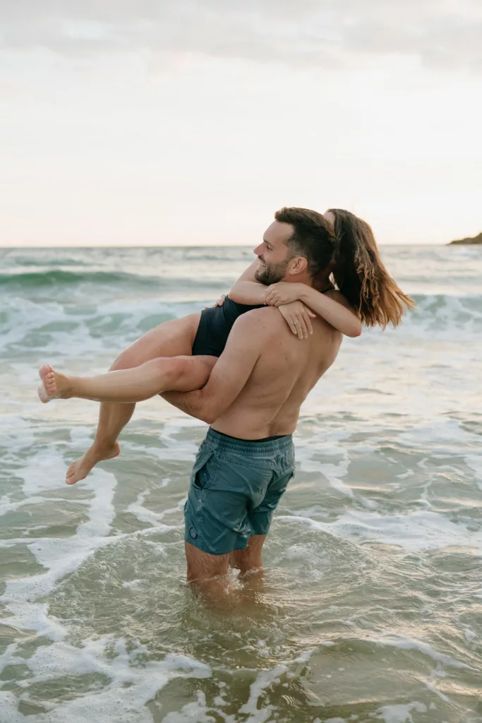 Éclat de rire du couple sous les embruns marins