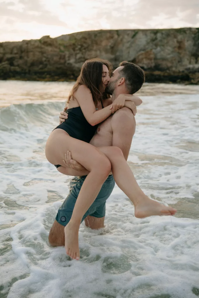 Couple s'embrassant dans les vagues à Port Blanc