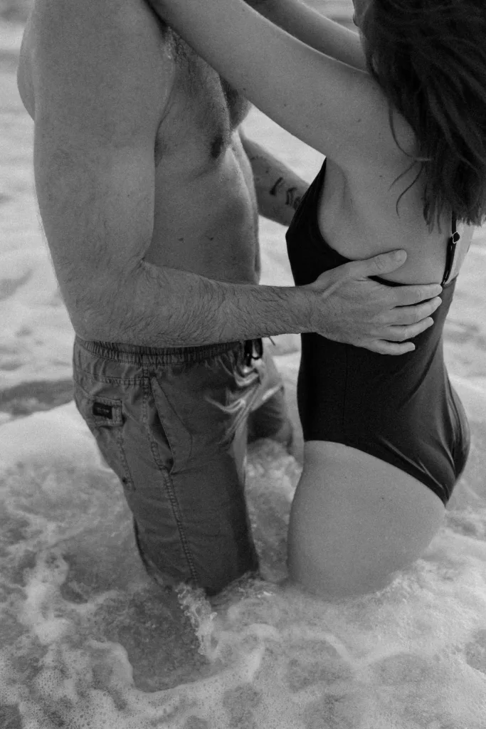 Couple jouant dans l'écume des vagues à Port Blanc
