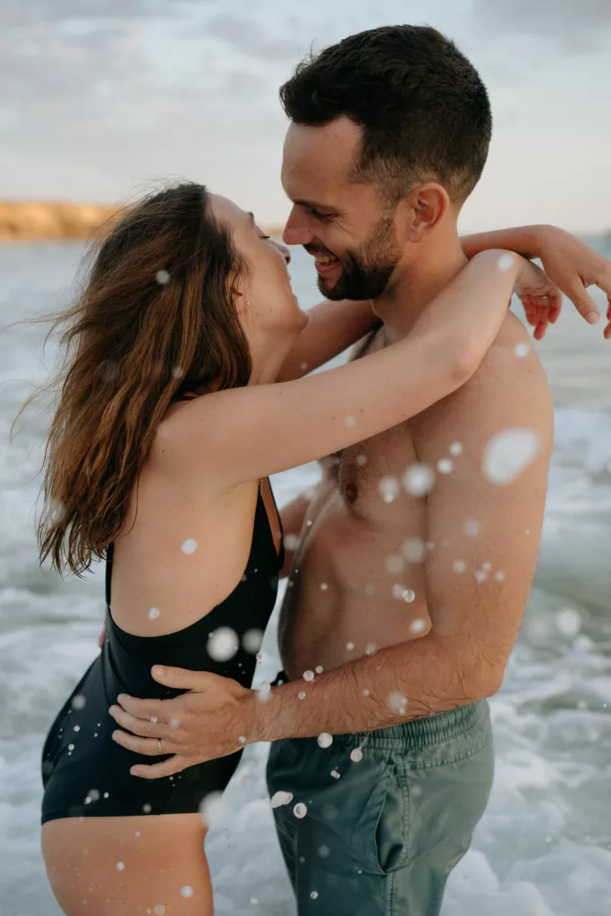 complices Éclaboussures et rires complices du couple dans l'eau quiberon