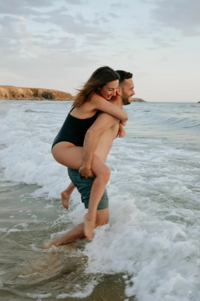 Couple s'éclaboussant au coucher du soleil Port Blanc